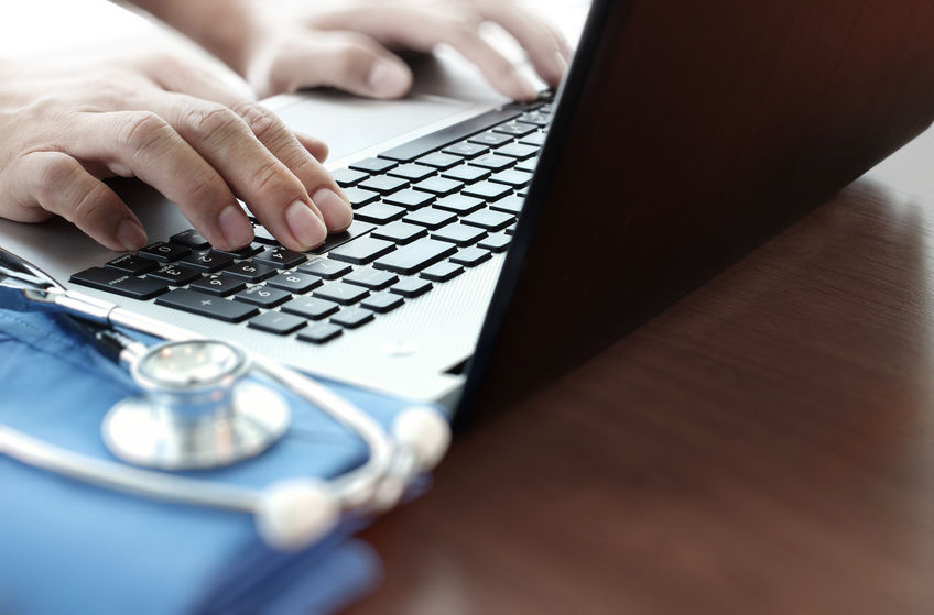 physician hands typing on laptop computer