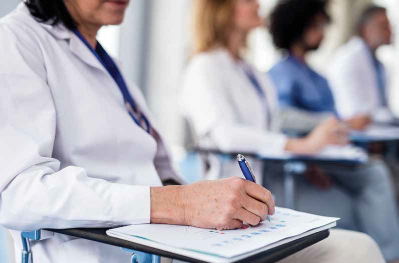 doctor at desk writing on a pad