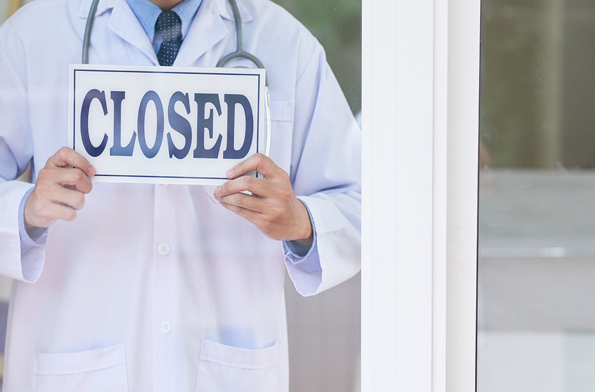 doctor holding closed sign