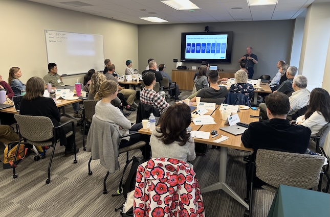 people in meeting room listening to a speaker
