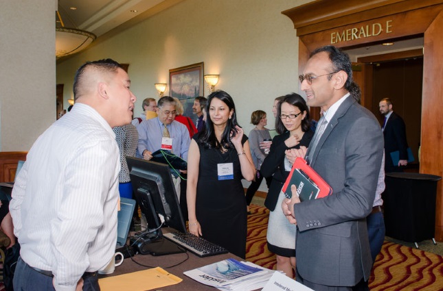 Physician meeting attendee and vendor talking