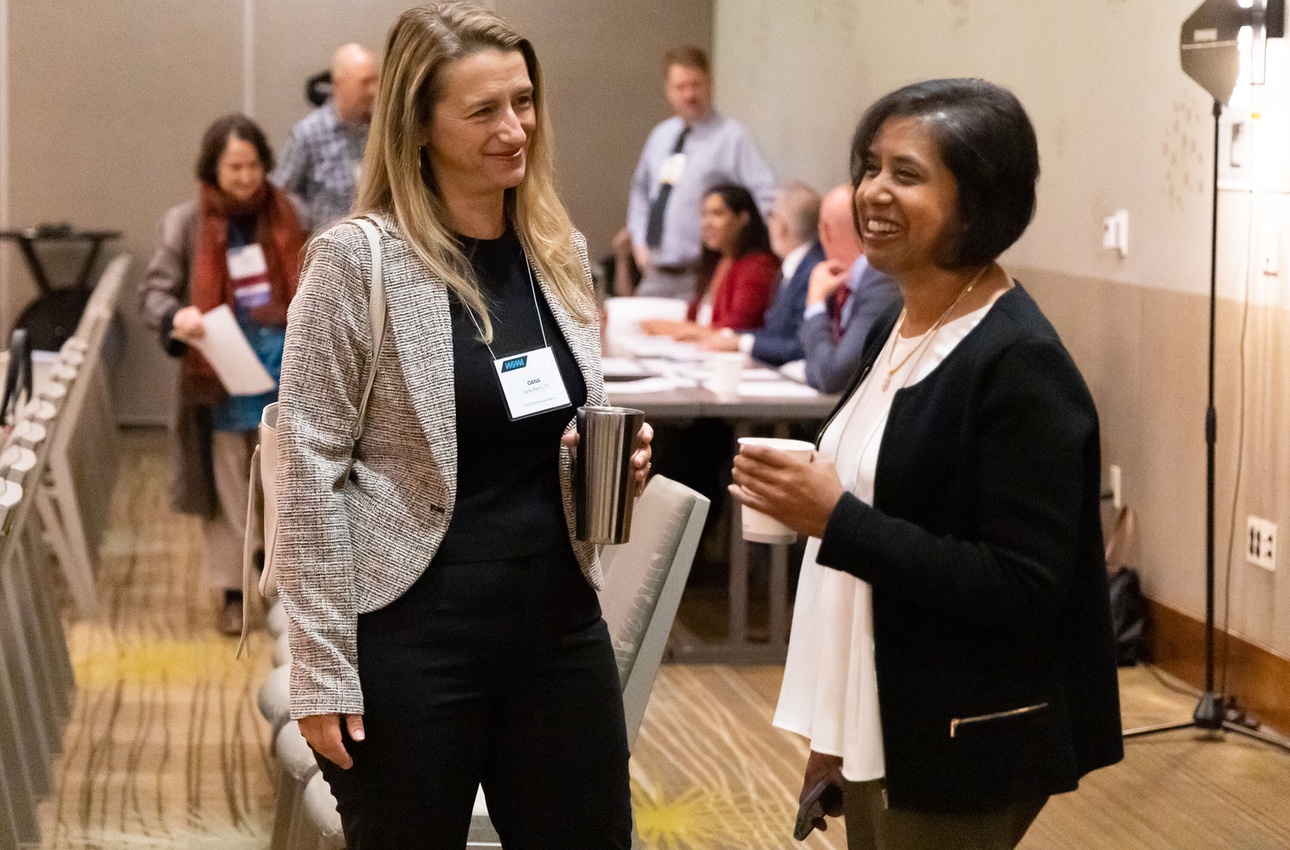 Two female physicians talking at a conference