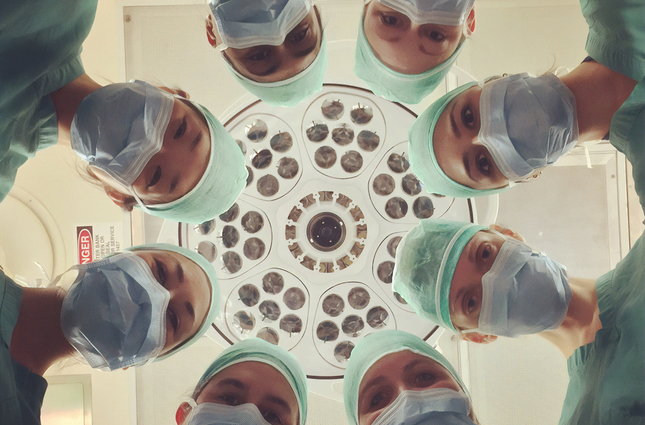circle of surgeons looking down on patient